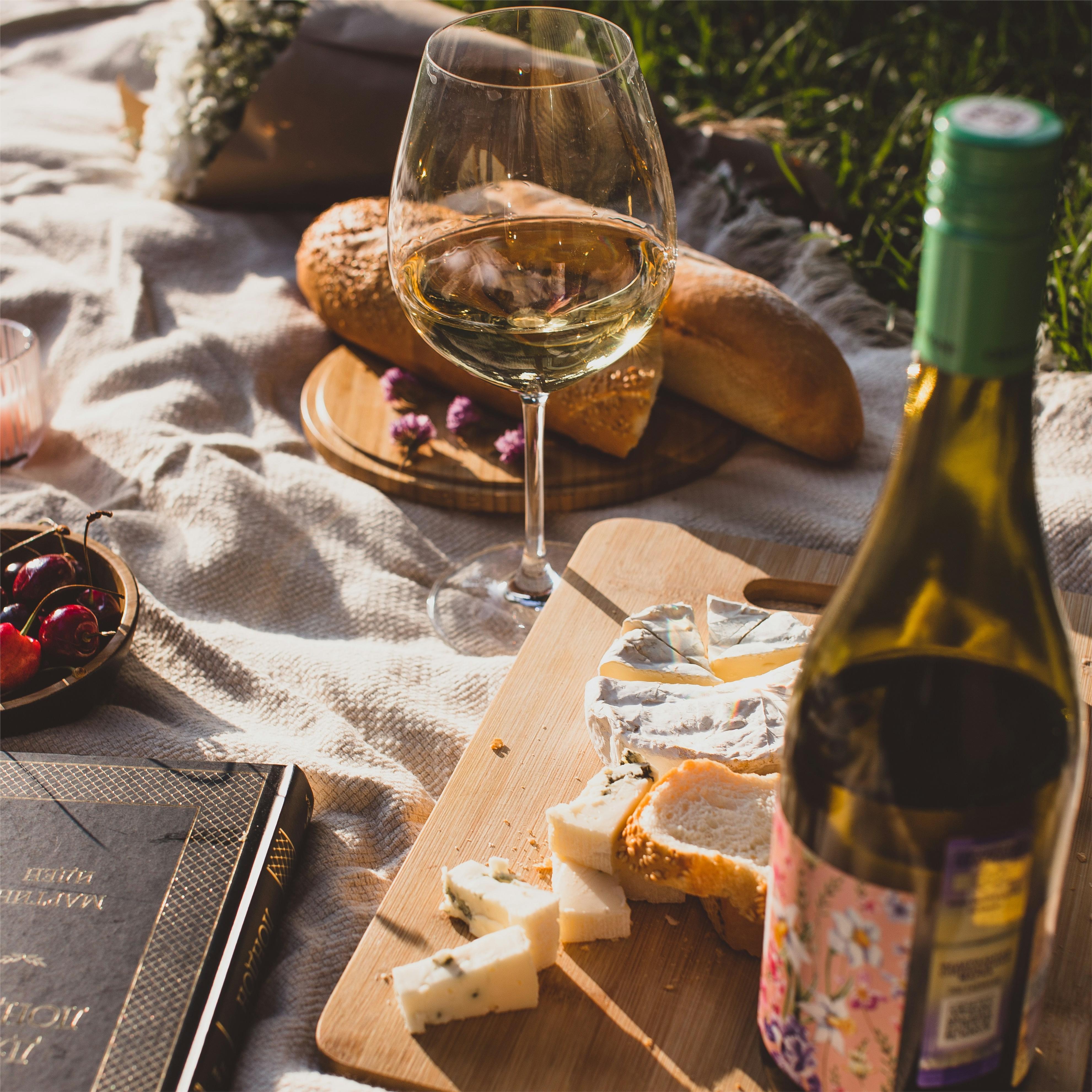 Picnic primaverile all'aperto con cibo gourmet e vini